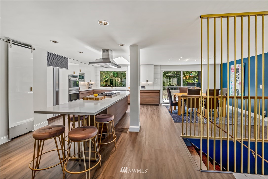 12833 Southeast 45th Place Bellevue, WA 98006 - Photo 8 of 40 a open kitchen with stainless steel appliances a dining table chairs and a large window
