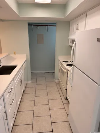 a kitchen with refrigerator a stove a sink and cabinets