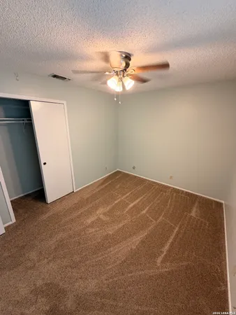 an empty room with a chandelier fan
