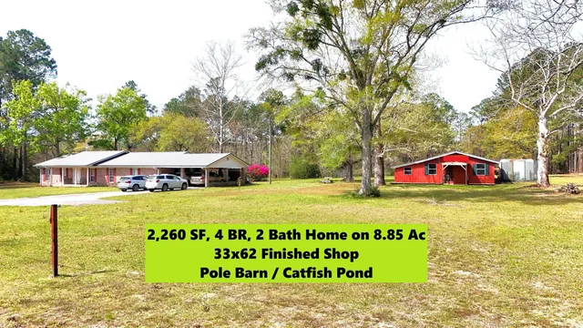 a sign that is sitting on a brick wall in front of the house