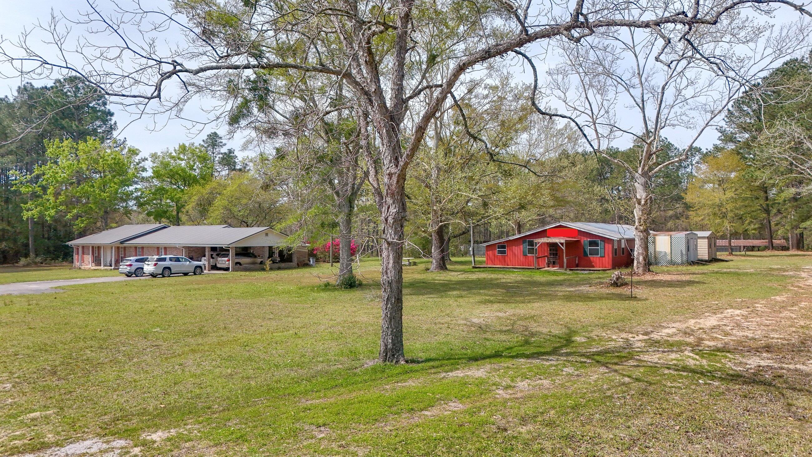 2374 Co Highway 280A DeFuniak Springs, FL 32435 - Photo 7 of 66 a view of a big yard with table and chairs under an umbrella