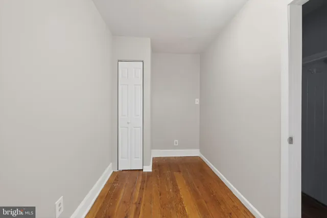 a view of a small space with wooden floor and a window