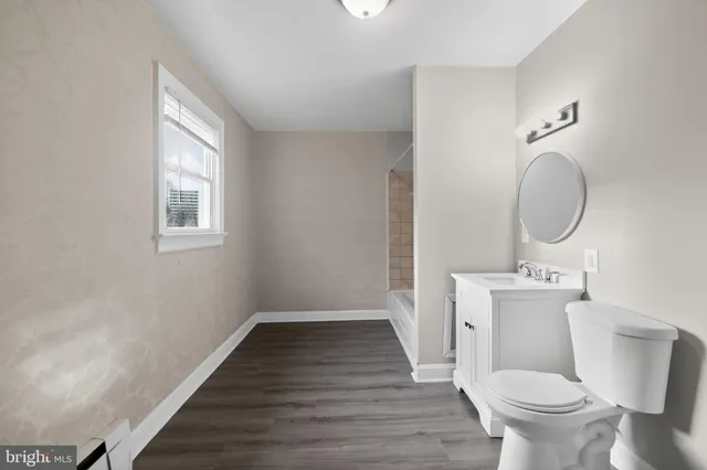 a bathroom with a toilet a sink and mirror