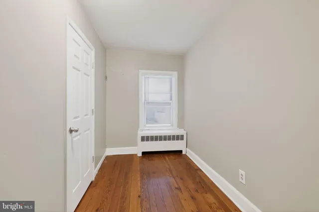 a view of a room with wooden floor and a window
