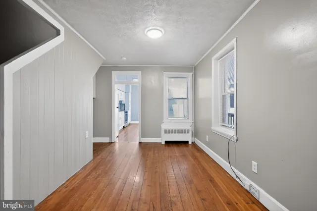 a view of a room with wooden floor and a window