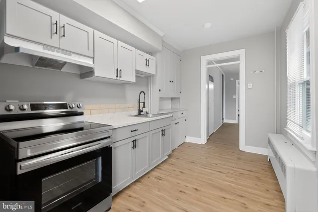 a kitchen with stainless steel appliances white cabinets and a sink