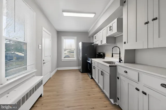 a kitchen with white cabinets and white appliances