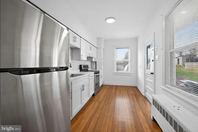 a view of a kitchen with wooden floor and electronic appliances