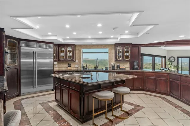 a kitchen with stainless steel appliances granite countertop a stove a sink and a refrigerator