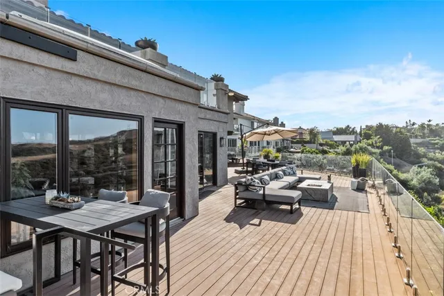 a view of a patio with table and chairs and floor to ceiling window with wooden floor