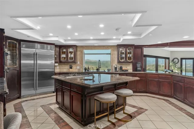 a kitchen with stainless steel appliances granite countertop a stove a sink and a refrigerator