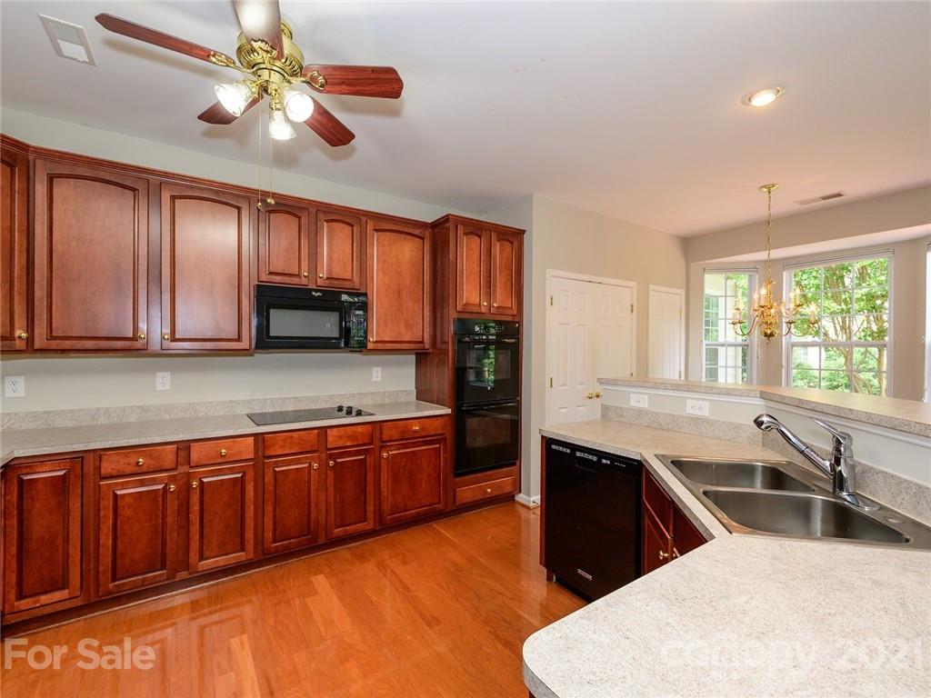 955 Platinum Drive Fort Mill, SC 29708 - Photo 13 of 37 a kitchen with stainless steel appliances granite countertop wooden cabinets a sink a stove a dining table and chairs