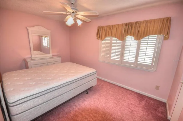 a bedroom with a bed chandelier and a window