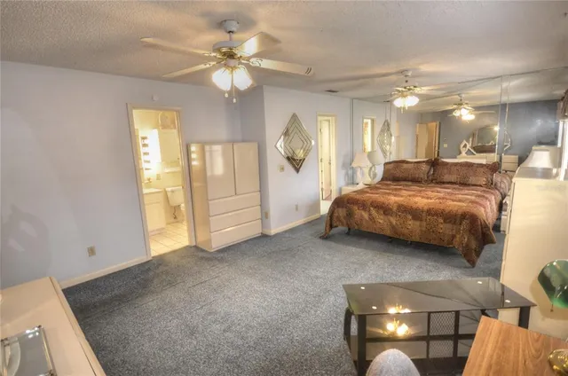 a spacious bedroom with a bed a chandelier and a window