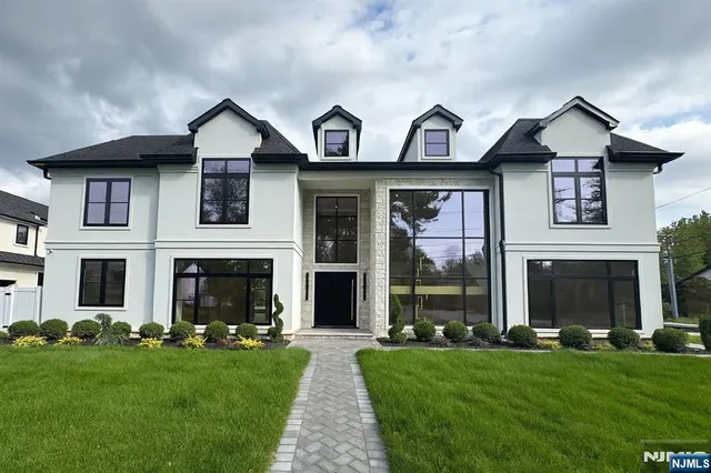 a front view of a house with a garden and yard