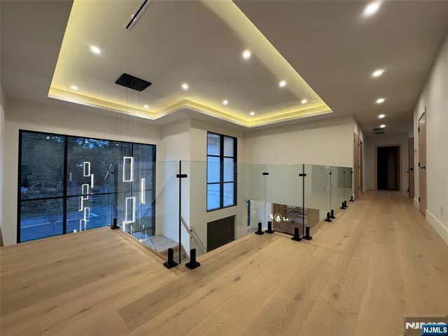 an empty room with wooden floor and a ceiling fan