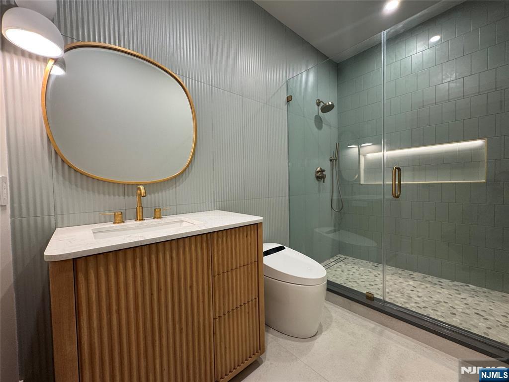 2 Maple Street Englewood Cliffs, NJ 07632 - Photo 29 of 44 a bathroom with a sink mirror toilet and shower