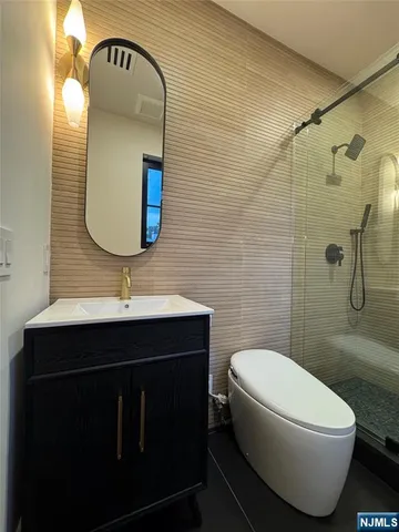 a view of an empty room with wooden floor and a sink