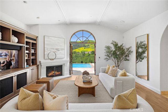 a living room with furniture a fireplace and a large window