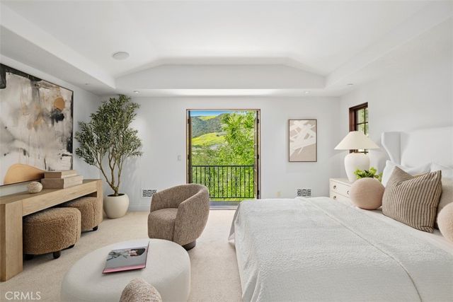 a bedroom with a bed a mirror and a window