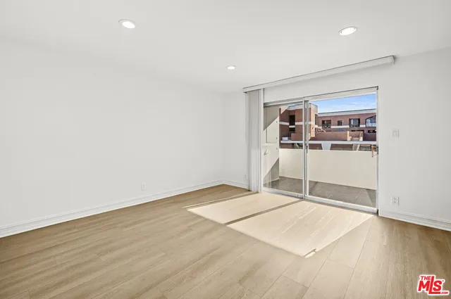 an empty room with wooden floor and window