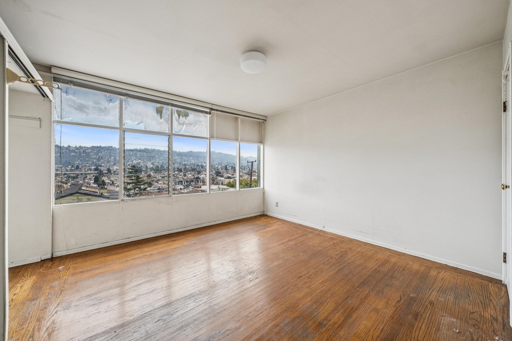 953 Hillside Avenue Albany, CA 94706 - Photo 36 of 48 a view of an empty room with wooden floor and a window
