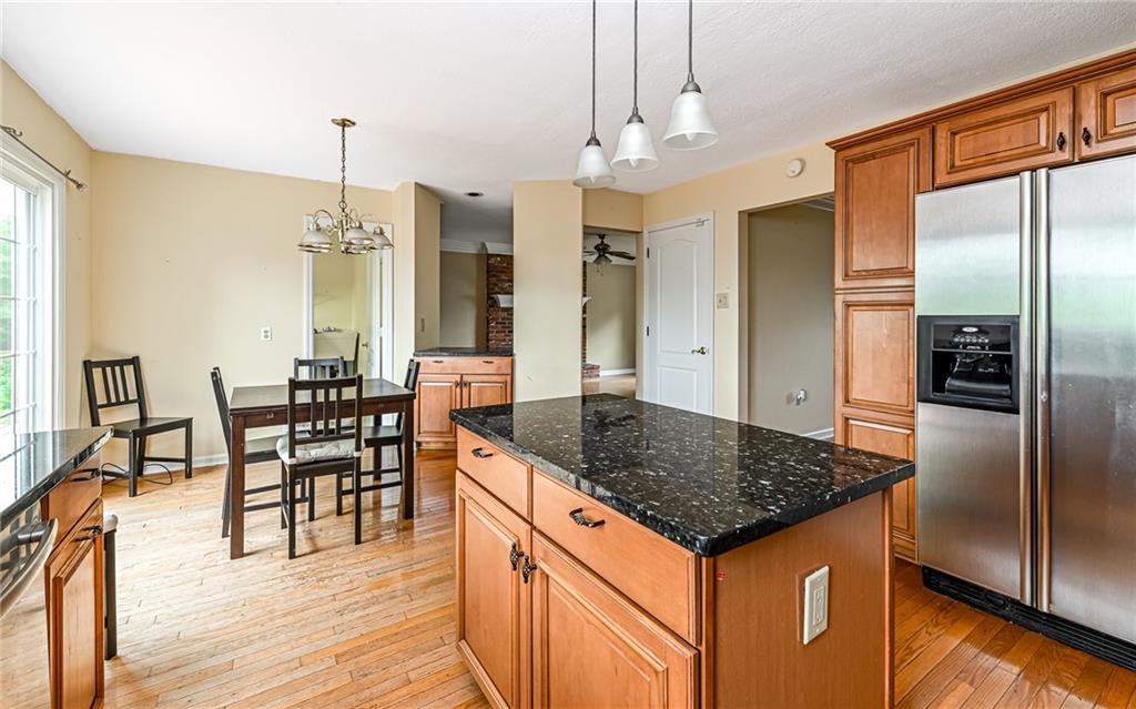 302 Ridgeway Drive Wexford, PA 15090 - Photo 7 of 28 a kitchen with granite countertop a table chairs stove and refrigerator