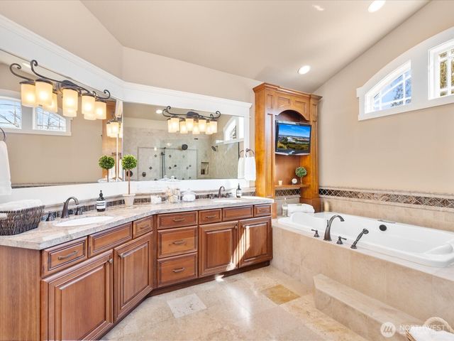 a spacious bathroom with a tub sink and mirror