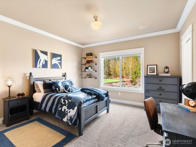 a spacious bedroom with a bed a table and chair