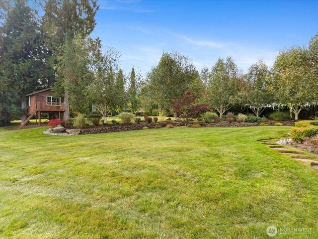 a view of a green field with houses in the background