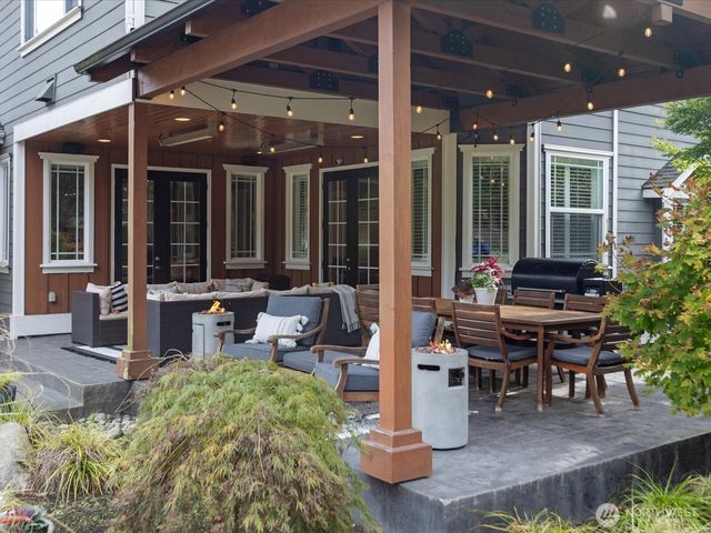 a view of a patio with table and chairs potted plants and floor to ceiling window
