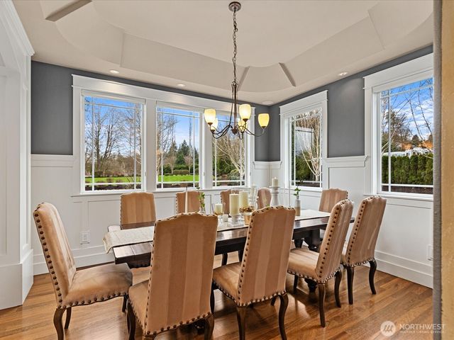 a dining room with furniture large windows and wooden floor