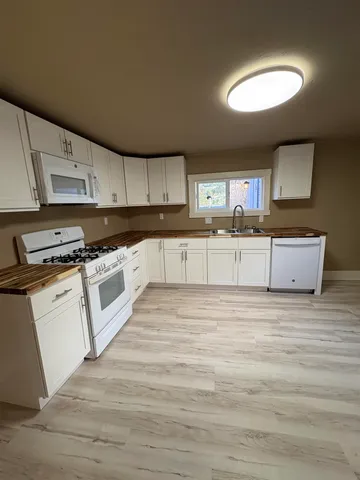 a kitchen with stainless steel appliances granite countertop a stove a sink and a microwave