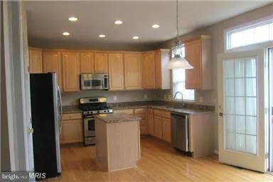 a kitchen with stainless steel appliances granite countertop a stove a refrigerator and a microwave