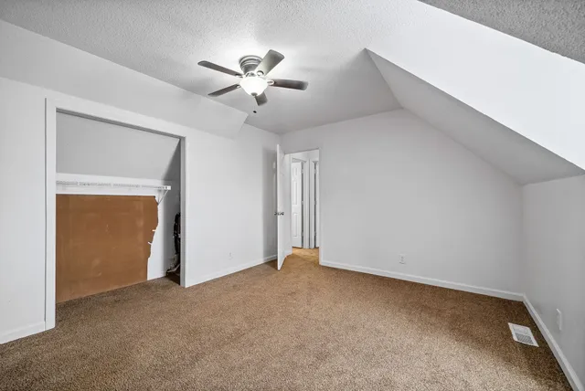 a view of an empty room with a chandelier fan