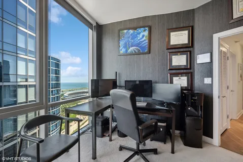a view of a workspace with furniture and a window