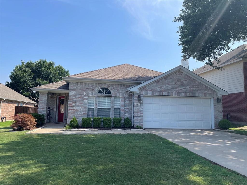 a front view of a house with a garden and yard