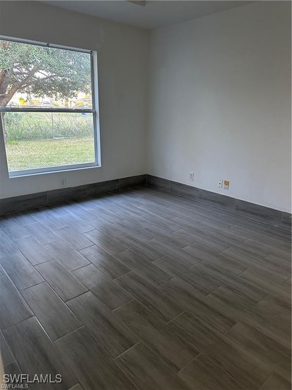 4520 19th Street Southwest Lehigh Acres, FL 33973 - Photo 5 of 11 an empty room with wooden floor and windows