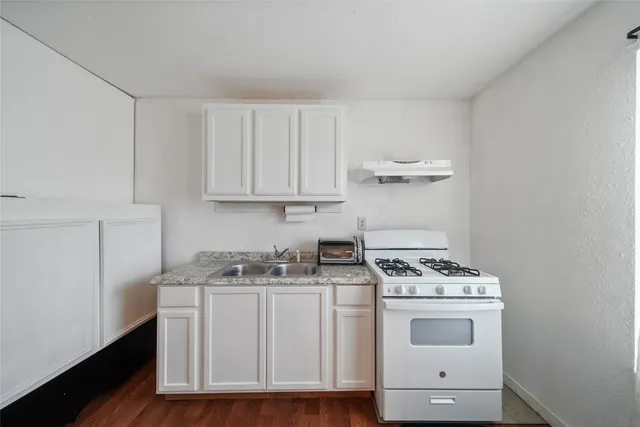 a kitchen with white cabinets and white appliances