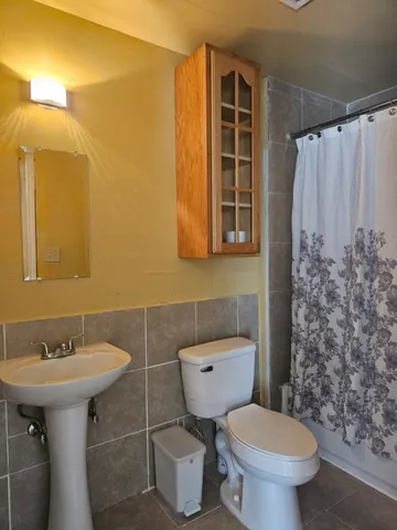 a bathroom with a sink toilet and shower
