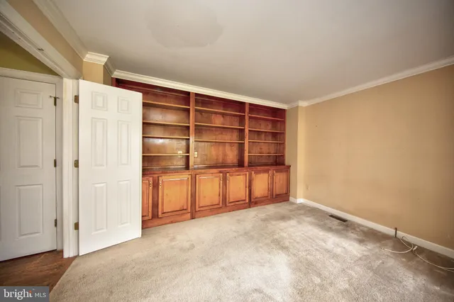 a view of an empty room with closet and racks