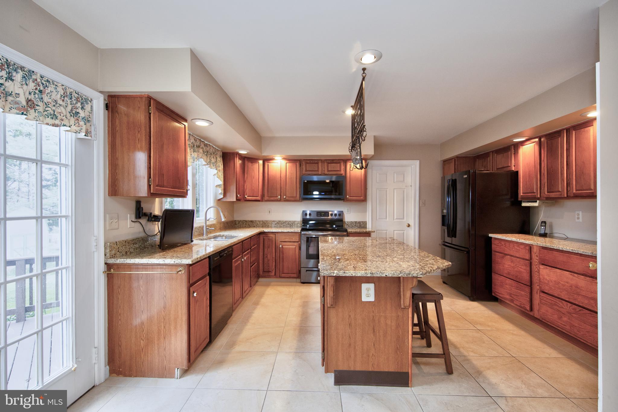 2502 Lady Ann Court Churchville, MD 21028 - Photo 15 of 48 a large kitchen with stainless steel appliances wooden cabinets a stove and a center island