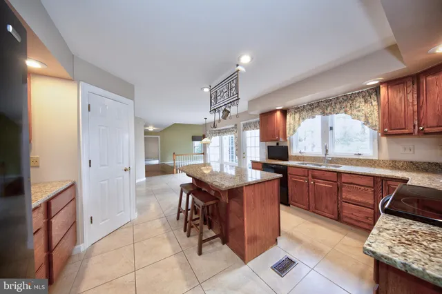 a kitchen with granite countertop cabinets a sink a counter space and stainless steel appliances
