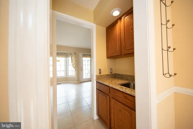 a bathroom with a granite countertop sink a mirror and shower