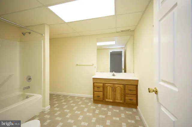 a bathroom with a granite countertop sink a mirror and bathtub