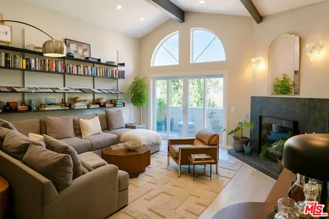 a living room with furniture fireplace and a large window
