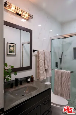 a bathroom with a granite countertop sink and a mirror