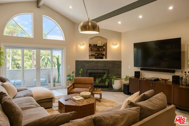 a living room with furniture fireplace and a large window