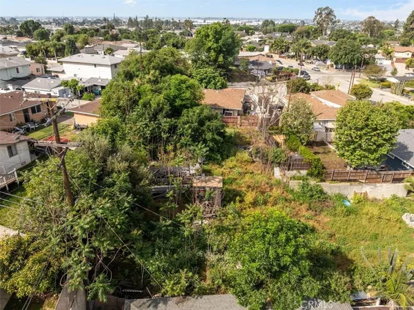 an aerial view of residential houses with outdoor space and trees