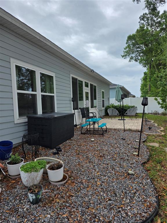 7875 Southwest 74th Street Ocala, FL 34474 - Photo 8 of 28 a view of a backyard with table and chairs potted plants and a tree